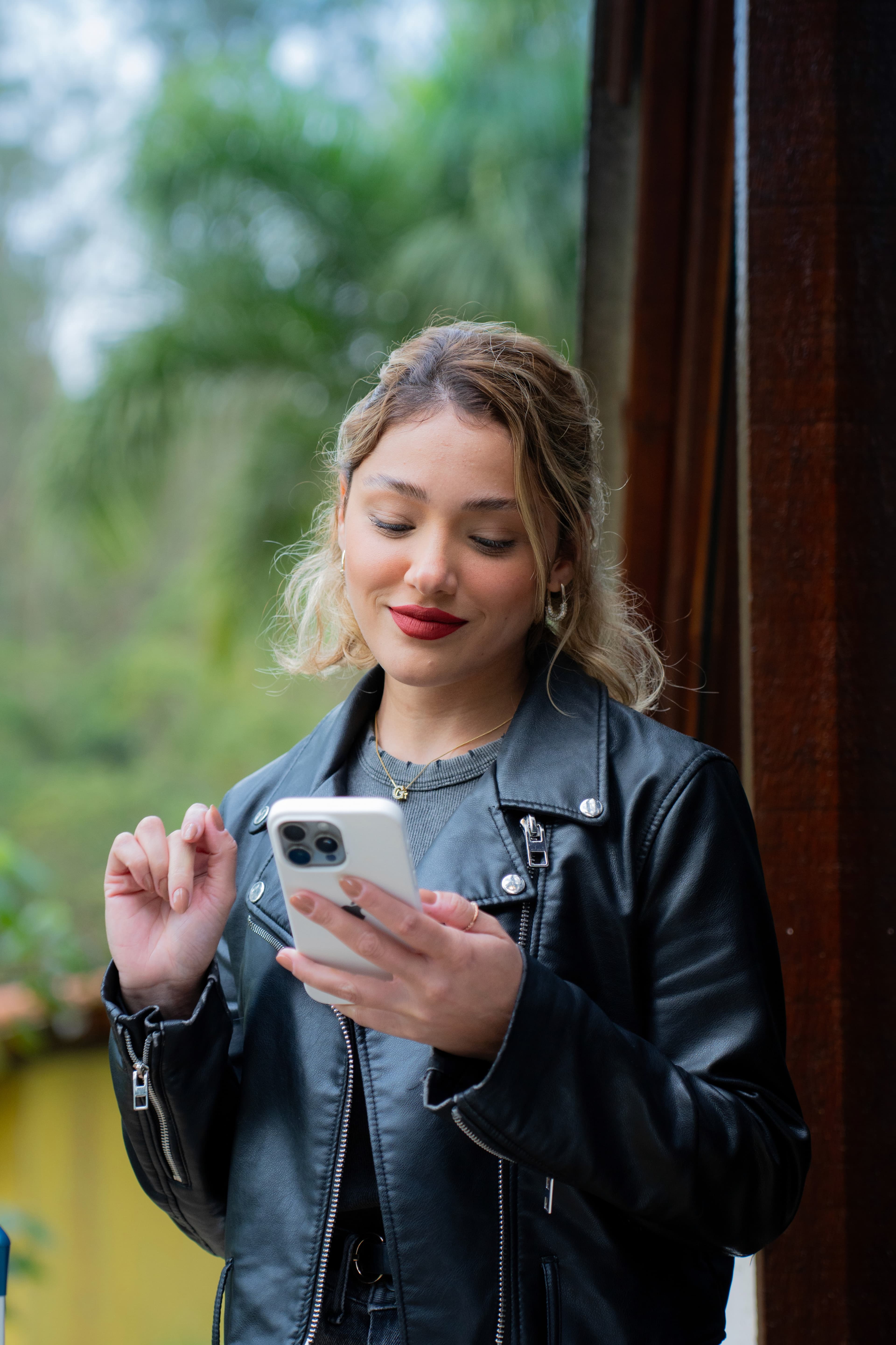 Usuária de jaqueta de couro usando o app no celular