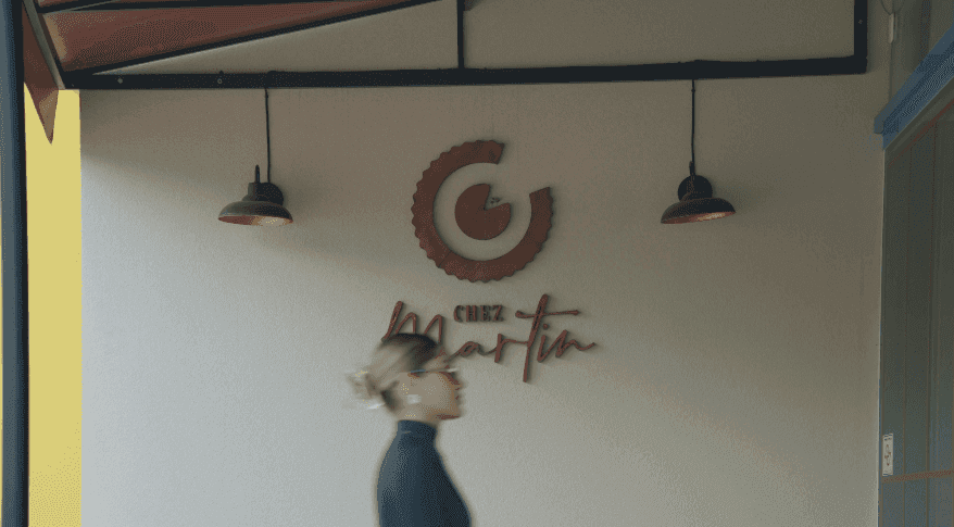 Marca do café na parede com cliente passando desfocada