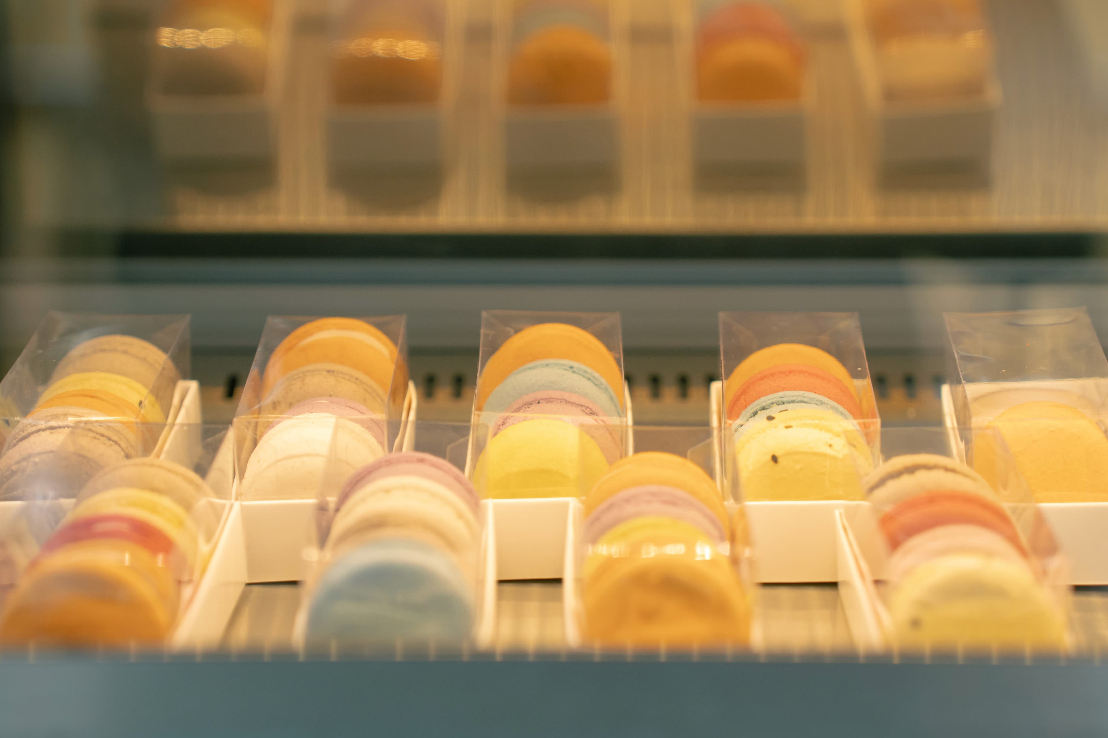 Macarons coloridos organizados nas bandejas da vitrine