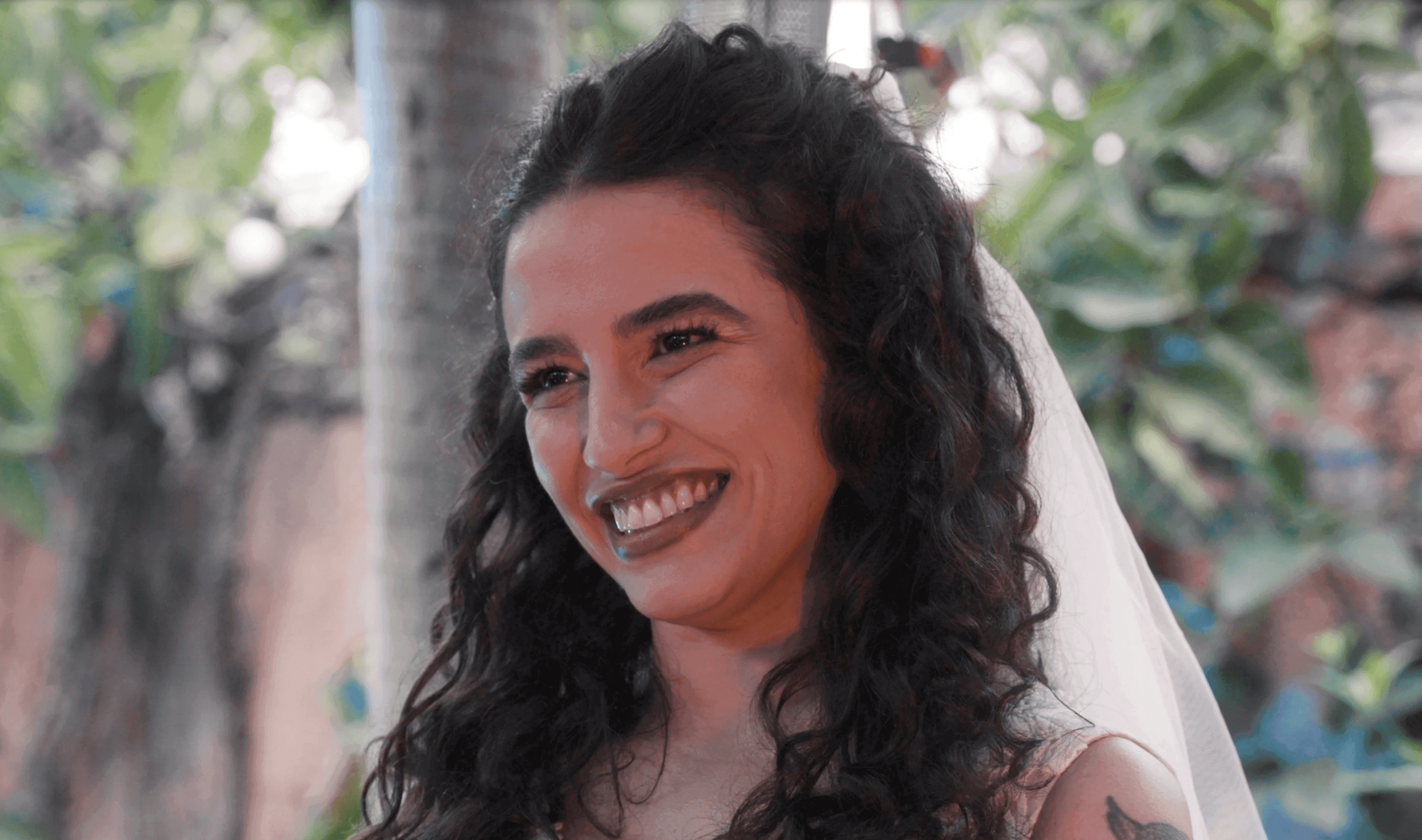 Noiva sorrindo de véu ao ar livre