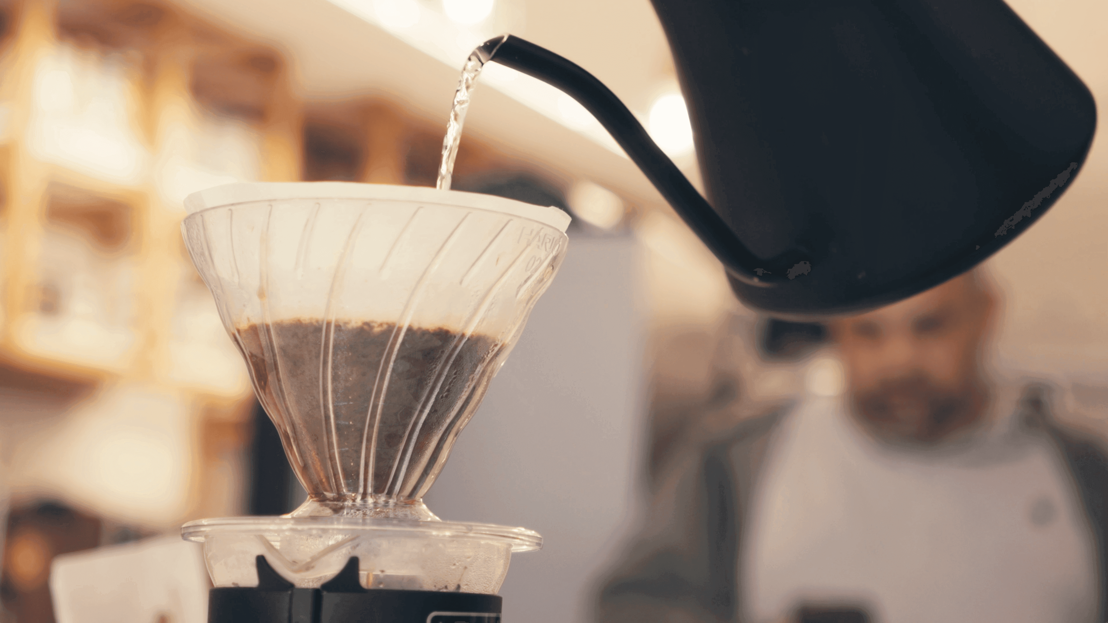 Café sendo despejado no filtro de coado
