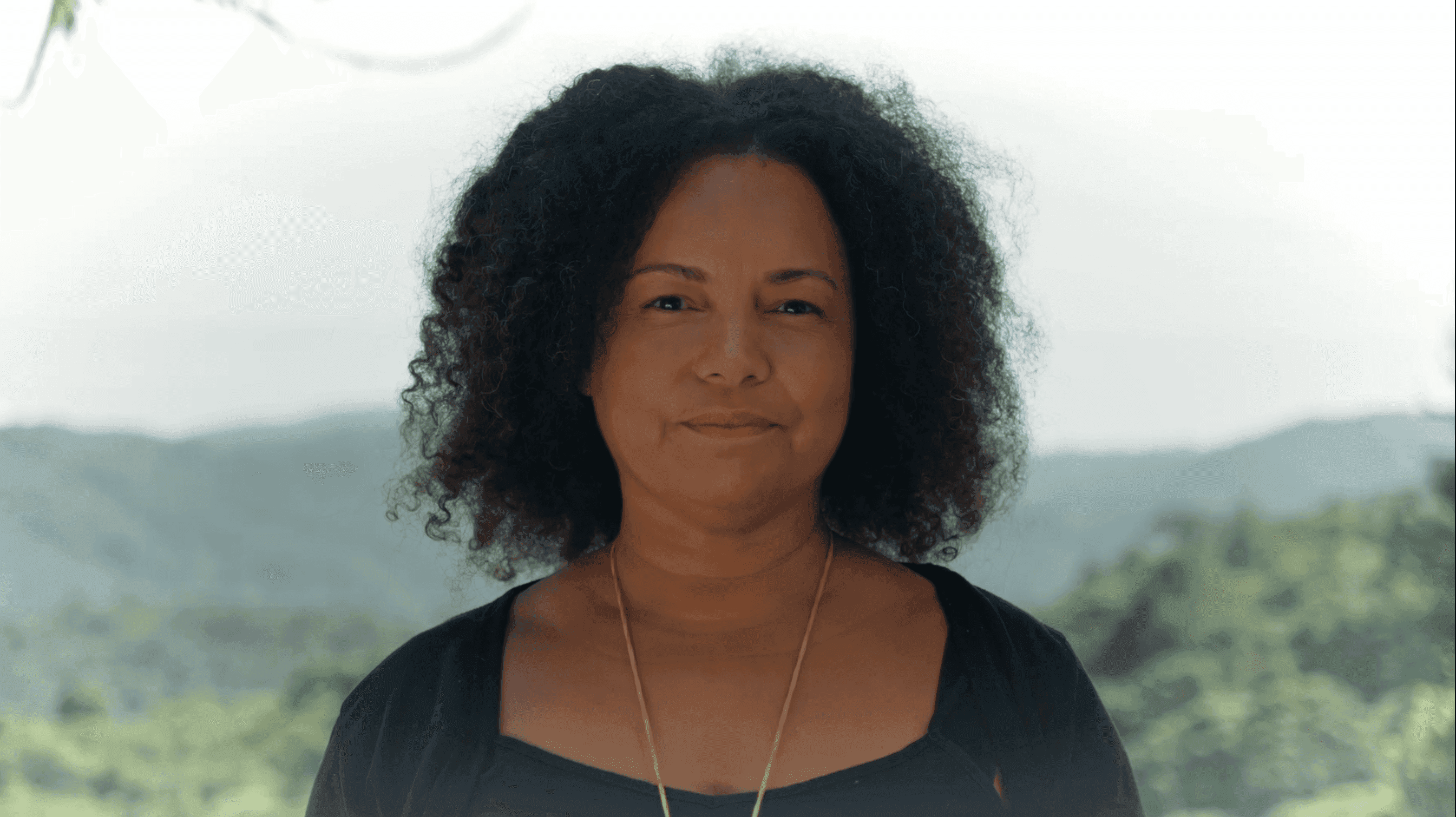 Retrato de mulher tendo a paisagem de montanha ao fundo